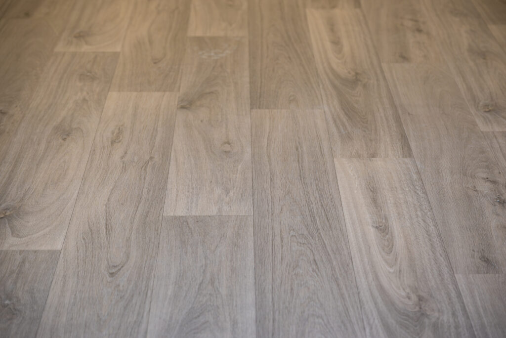 Gros plan d'un parquet posé dans un appartement rénové, mettant en avant la texture et la finition soignée du sol.